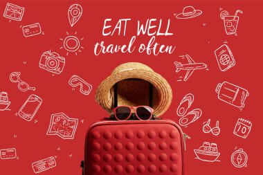 Kırmızıda izole edilmiş hasır şapkalı ve güneş gözlüklü kırmızı renkli seyahat çantası. İyi ye, sık sık seyahat et. 