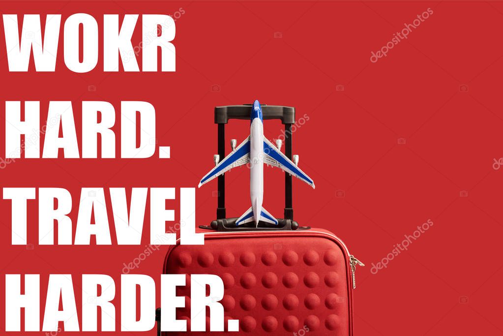 red colorful textured travel bag with plane model isolated on red with work hard, travel harder illustration