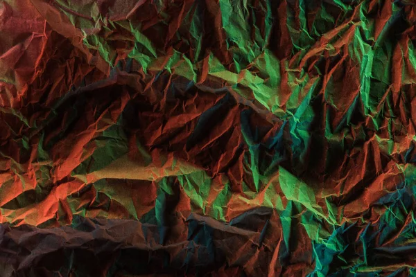 Widok Góry Zmięty Papier Zielonym Kolorowym Oświetleniem Ciemności — Zdjęcie stockowe