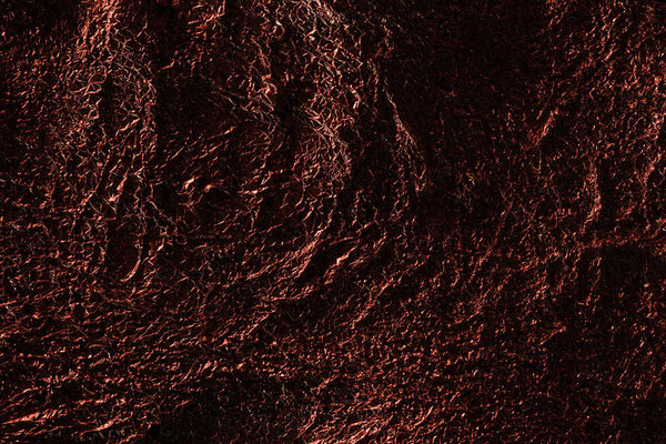 abstract background of silver textured crumpled foil with red lighting