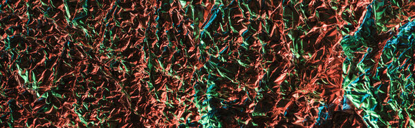panoramic shot of crumpled foil with colorful illumination