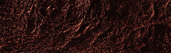 panoramic shot of abstract background of shiny textured crumpled foil with red lighting