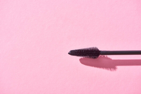 top view of brush for mascara on pink background 