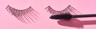 panoramic shot of brush for mascara and false eyelashes on pink background  clipart