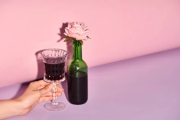 裁剪视图的妇女拿着玻璃与葡萄酒在五颜六色的背景 — 图库照片