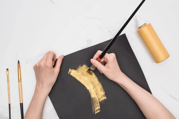 Cropped View Artist Drawing Golden Paint Black Paper Marble Surface — Stock Photo, Image