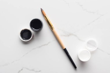 yüzde işareti düzenlenmiş mermer beyaz yüzey üzerinde boya ve Paintbrush üst görünümü