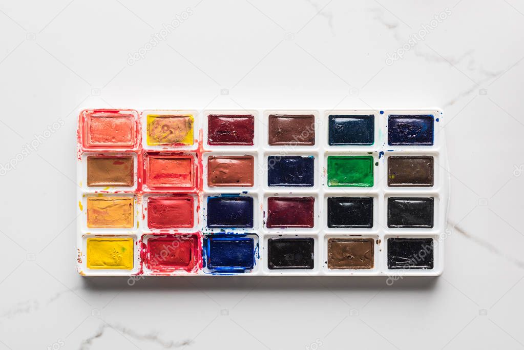 watercolor bright paint palette on marble white surface