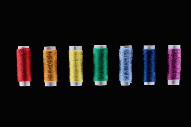 top view of bright and colorful threads isolated on black clipart