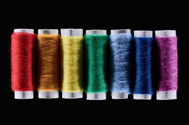 top view of bright and colorful threads isolated on black clipart