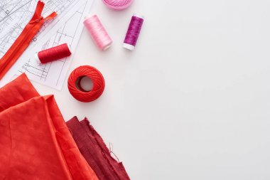 ipliklerin üst görünümü, örgü iplik topu, kumaş, dikiş desenleri ve beyaz arka plan üzerinde fermuar 