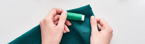 панорамный снимок швеи, держащей красочную ткань и нить на белом фоне
 