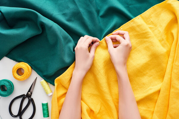 обрезанный вид швеи шитья красочные ткани с иглой на белом фоне
 