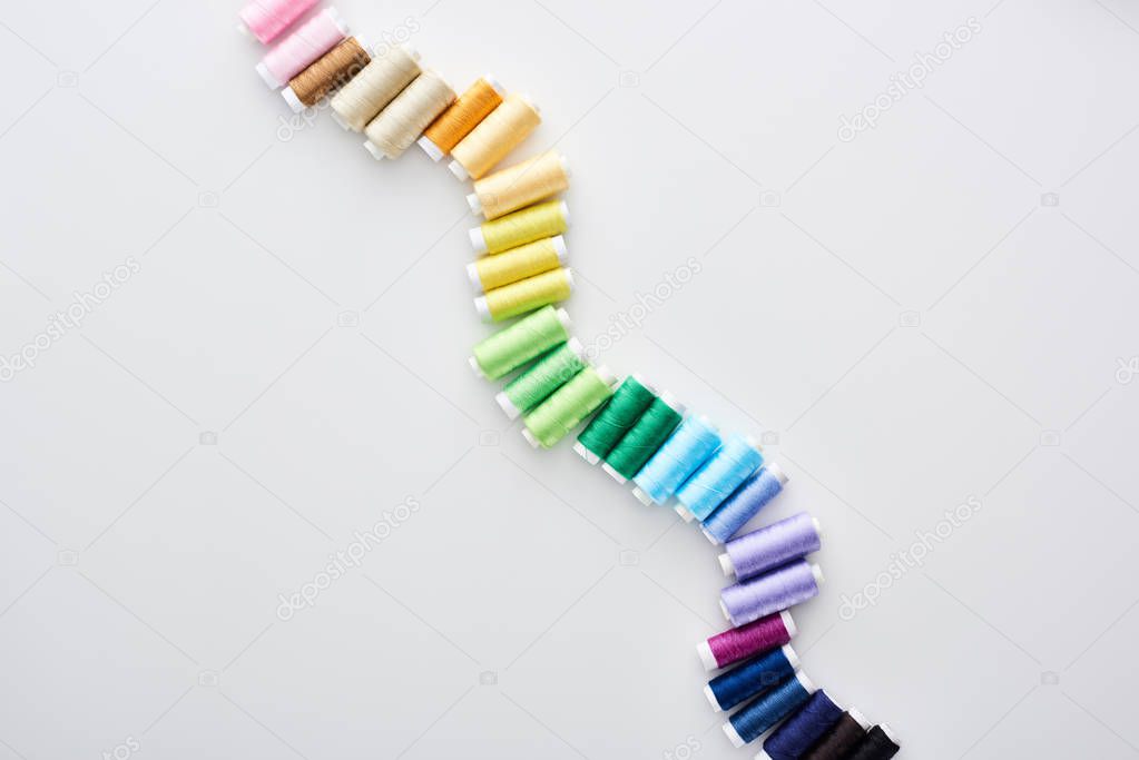 top view of bright and colorful threads on white background 
