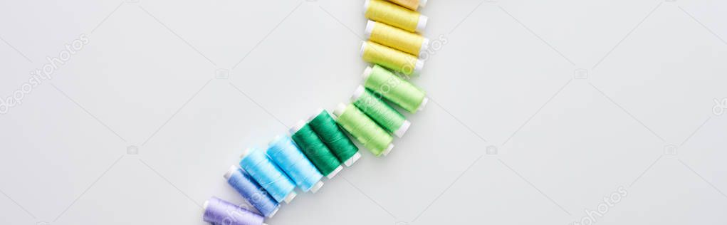 panoramic shot of bright and colorful threads on white background 