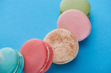 mavi parlak arka plan üzerinde çok renkli lezzetli Fransız macaroons yakından görünümü