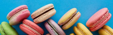 mavi parlak arka plan, panoramik çekim lezzetli çeşitli Fransız macaroons üst görünümü