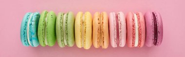pembe arka plan, panoramik çekim üzerinde doğrultusunda renkli taze lezzetli Fransız macaroons üst görünümü