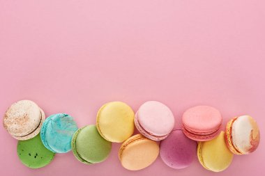 kopya alanı ile pembe arka plan üzerinde çok renkli lezzetli Fransız macaroons üst görünümü