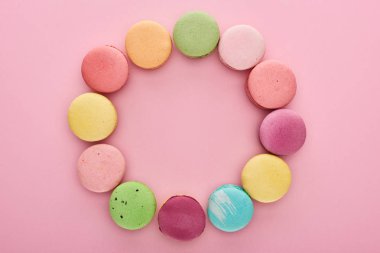 pembe arka plan üzerinde kopya alanı ile çok renkli lezzetli Fransız macaroons çerçeve