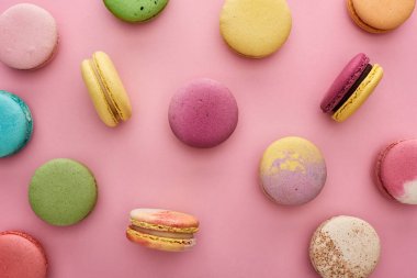 pembe arka plan üzerinde dağınık çok renkli lezzetli Fransız macaroons desen
