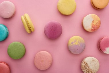 pembe arka plan üzerinde dağınık çok renkli lezzetli Fransız macaroons desen