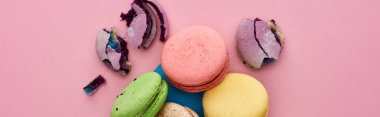 pembe arka plan, panoramik çekim üzerinde mavi posta zarfı içinde çok renkli lezzetli Fransız macaroons üst görünümü
