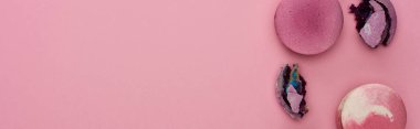 kopya alanı ile pembe arka plan üzerinde parçalanmış ve bütün mor Fransız macaroons üst görünümü, panoramik çekim