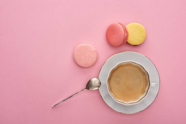 kopya alanı ile pembe arka plan üzerinde kahve yakınında lezzetli Fransız macaroons üst görünümü