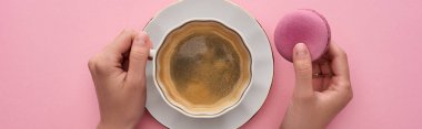 pembe arka plan, panoramik çekim üzerinde lezzetli Fransız macaroon ile kahve içen kadın kırpılmış görünümü