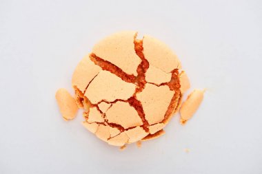 top view of delicious sweet orange smashed French macaroon isolated on white clipart