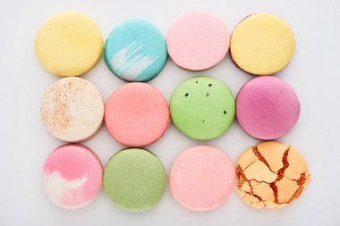 düz beyaz arka plan üzerinde farklı tatlar lezzetli renkli Fransız macaroons ile yatıyordu