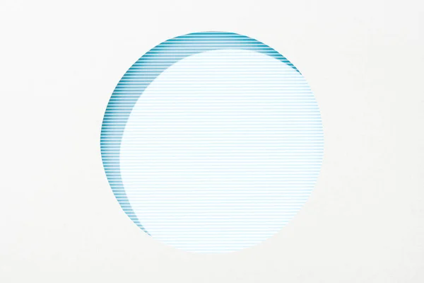 Çizgili Mavi Arka Plan Üzerinde Beyaz Kağıt Yuvarlak Delik Kesip — Stok fotoğraf