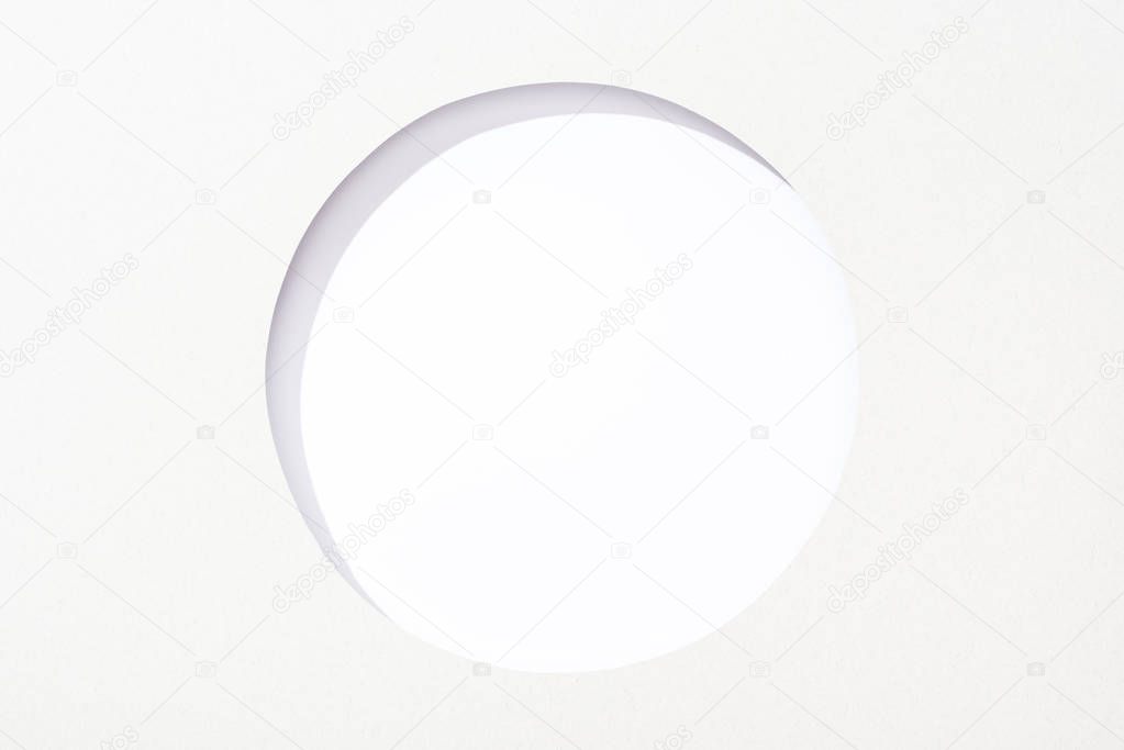 cut out round hole in white paper on white background