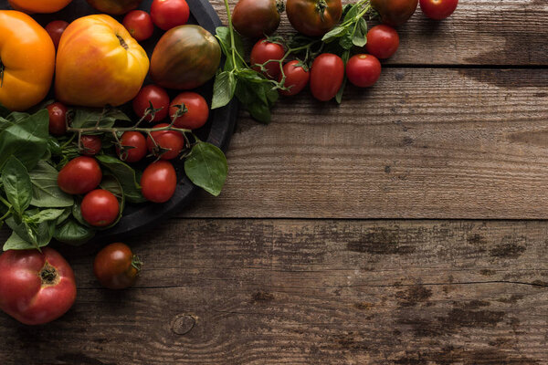 вид помидоров и шпината на кастрюлю для пиццы на деревянном столе
