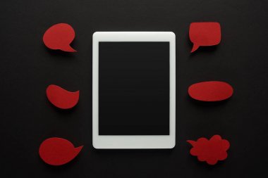 boş kırmızı konuşma kabarcıkları, siber zorbalık kavramı ile siyah arka plan üzerinde boş ekran ile dijital tablet üst görünümü