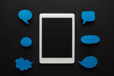 top view of digital tablet on black background with empty blue speech bubbles, cyberbullying concept clipart