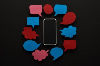 boş konuşma kabarcıkları, siber zorbalık kavramı ile siyah arka plan üzerinde boş ekran ile akıllı telefon üst görünümü