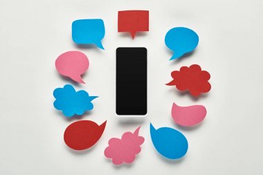 boş renkli konuşma kabarcıkları, siber zorbalık kavramı yakınında beyaz arka plan üzerinde boş ekran ile akıllı telefon üst görünümü