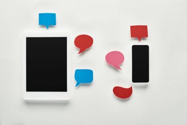 boş konuşma baloncukları, siber zorbalık kavramı yakınında beyaz arka plan üzerinde boş ekran ile dijital tablet reklam akıllı telefon üst görünümü