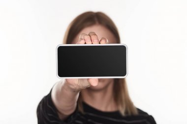 selective focus of victim of cyberbullying presenting smartphone with blank screen isolated on white clipart