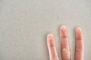 gri arka planda üç parmak gösteren adam kırpılmış görünümü
