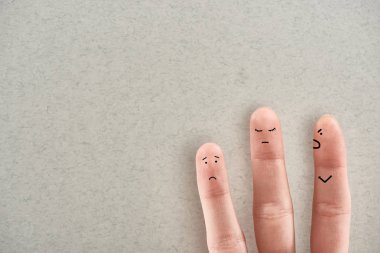 gri arka plan üzerinde agresif istismarcı ve üzgün kurbanları simgeleyen üç parmak gösteren adamın kısmi görünümü
