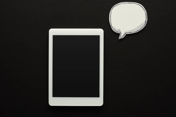top view of digital tablet with blank screen on black background near empty white speech bubble, cyberbullying concept