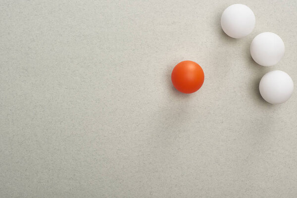 top view of balls symbolizing victim and abusers on grey background