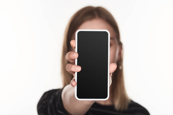 selective focus of victim of cyberbullying showing smartphone with blank screen isolated on white