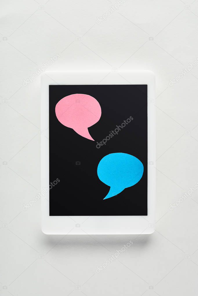 top view of digital tablet with empty speech bubbles on screen on white background, cyberbullying concept
