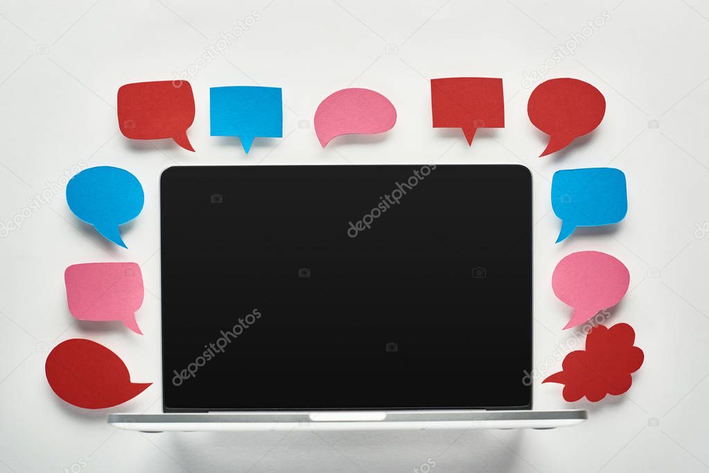 laptop with blank screen on white background with empty speech bubbles around screen, cyberbullying concept