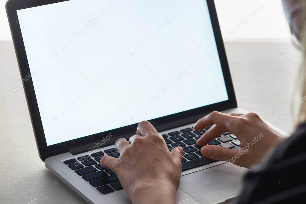cropped view of girl typing on laptop keyboard, cyberbullying concept