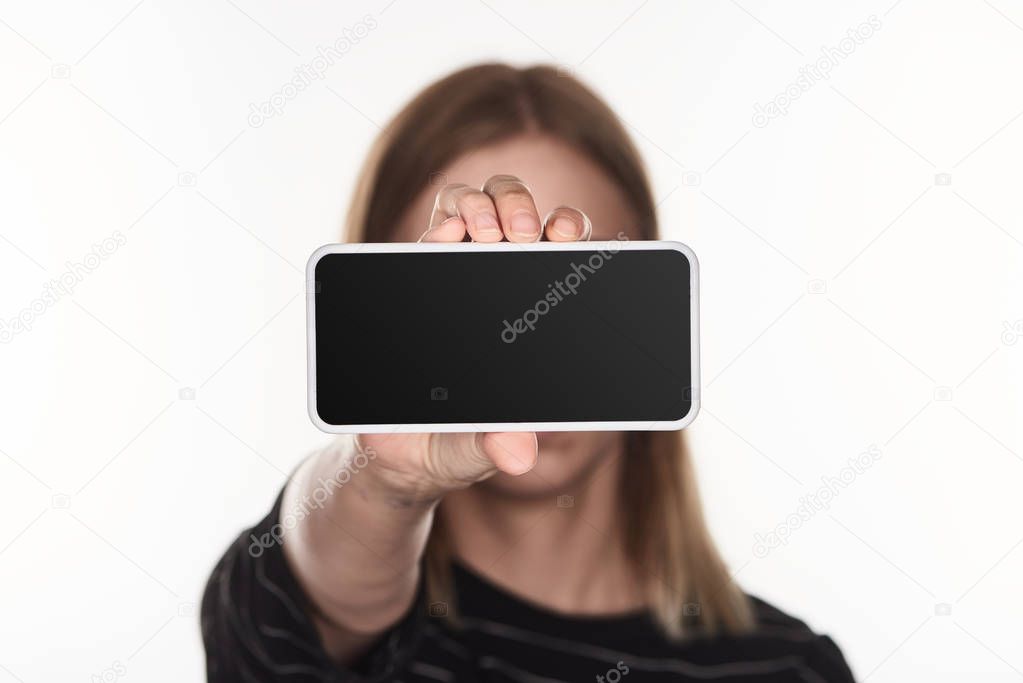 selective focus of victim of cyberbullying presenting smartphone with blank screen isolated on white